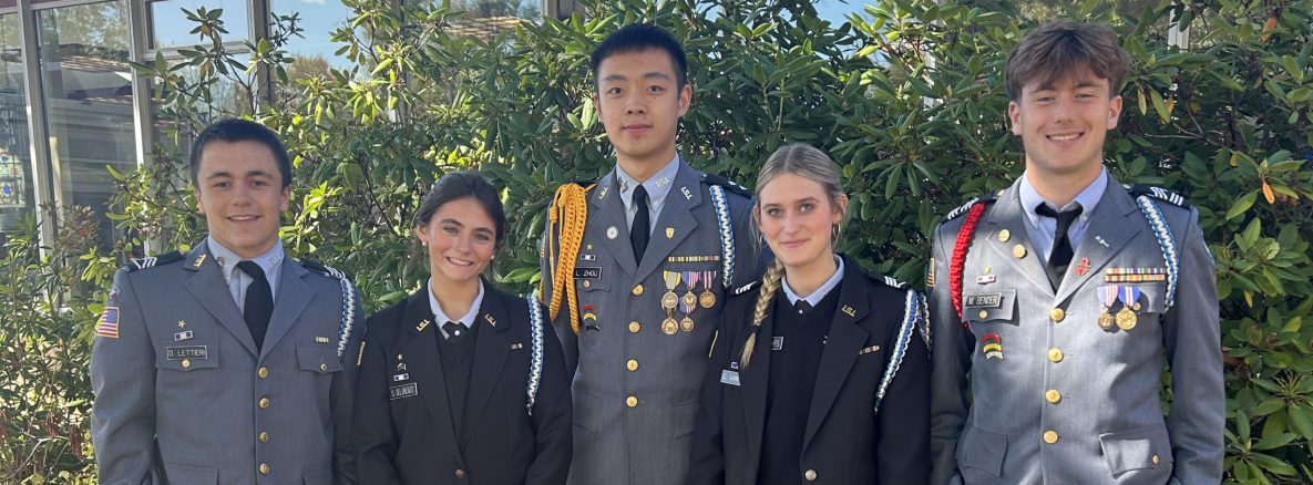 5 Students in uniform in front of the school